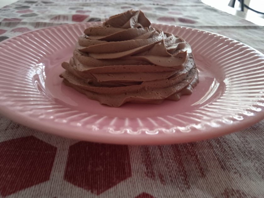 Trufa cocida de chocolate acabada y puesta en un plato de color rosa.