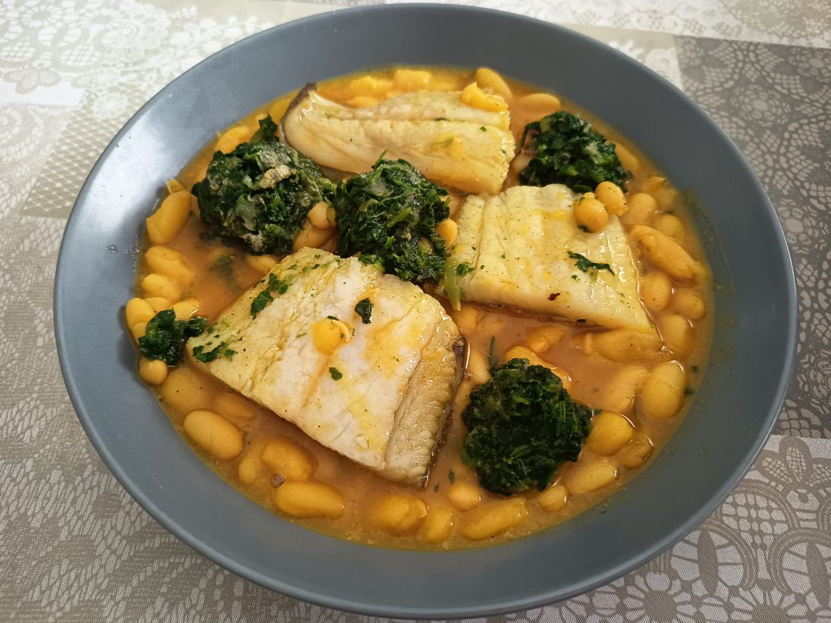 receta acabada de guiso de judías con bacalao y pimentón acabada puesta en un palto hondo.