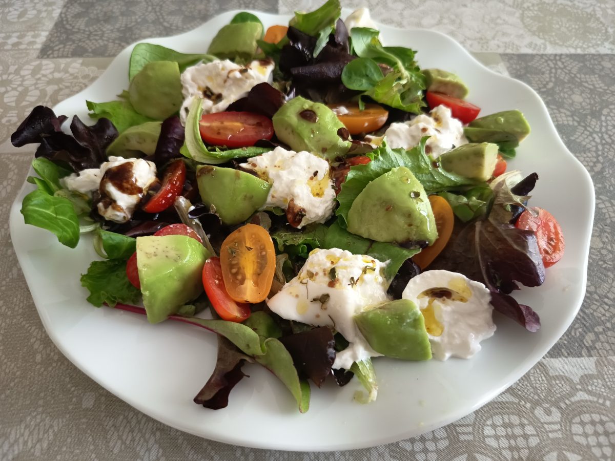 Ensalada con burrata tomates cherrys Y aguacate aliñada con una vinagreta de aceite de oliva vinagre de módena y or egan