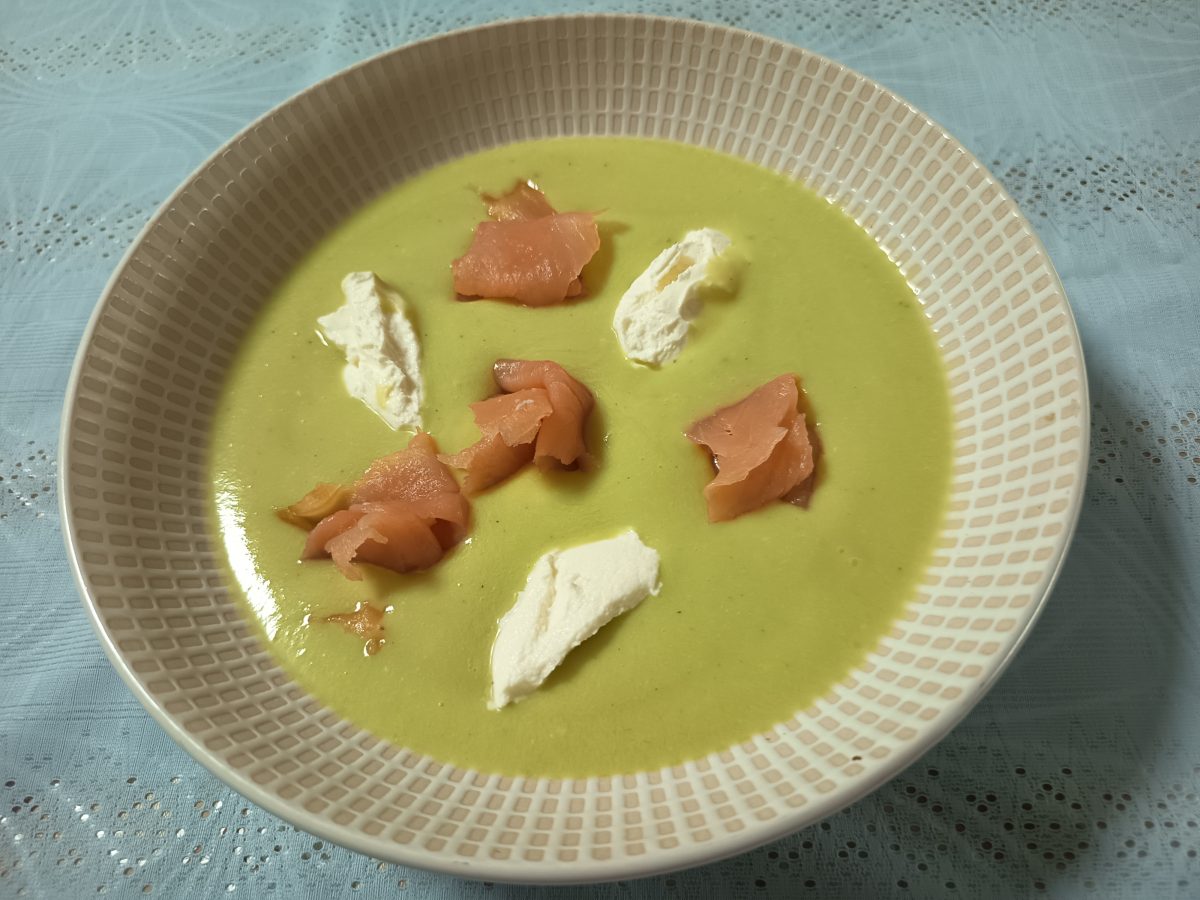 Receta de crema de aguacate puesta en un plato hondo con una guarnición de queso crema y salmón ahumado lista para servir.