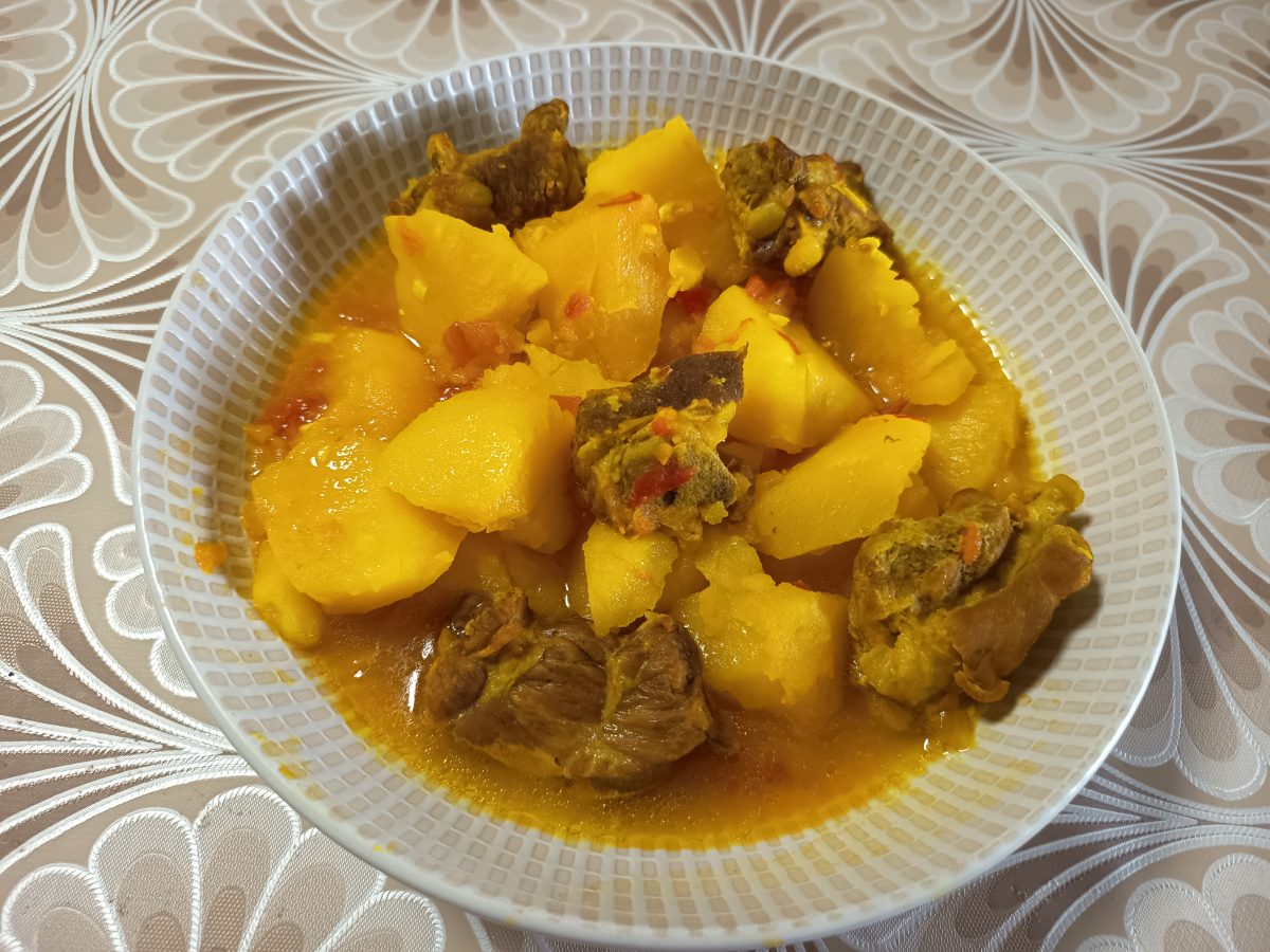 Receta de patatas guisadas caseras con costillas de cerdo puestas en un plato hondo listas para comerlas.
